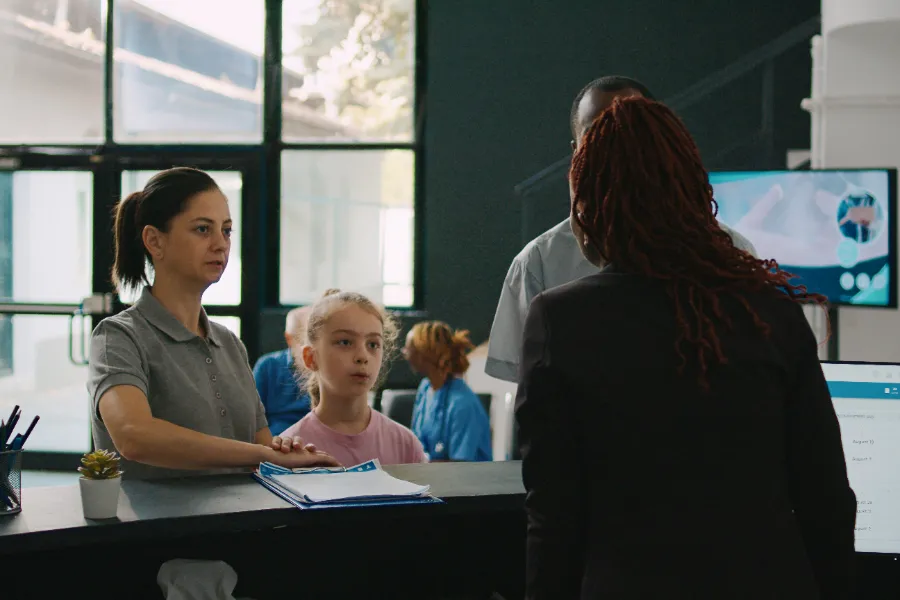 Family checking in at a community health center reception desk