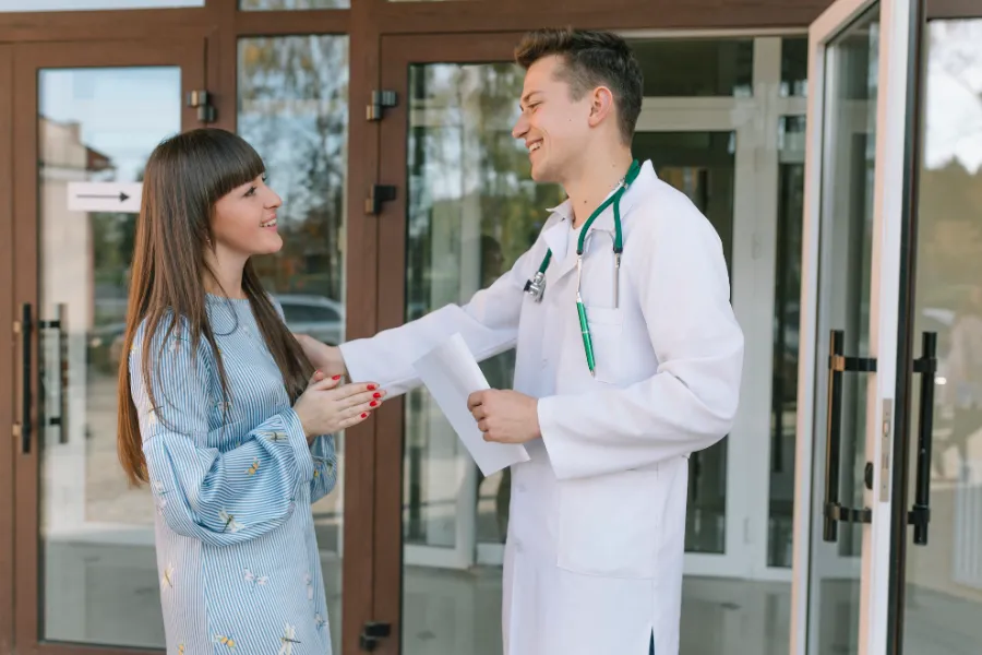 Physician greeting a patient at a clinic entrance